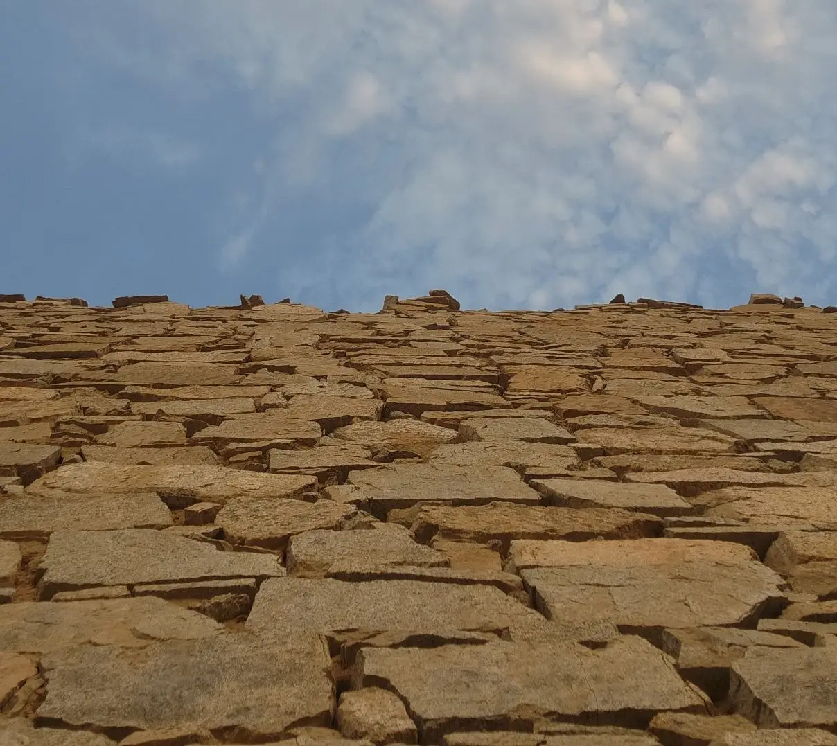 Foto de um muro de pedra de arenito, com seus segmentos de construção e céu azul ao fundo, fazendo referência à possibilidade de segmentação de clientes para mais sucesso nos negócios.