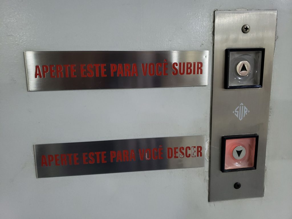 botões de elevador mostrando comunicação não eficaz com duplicidade de informação