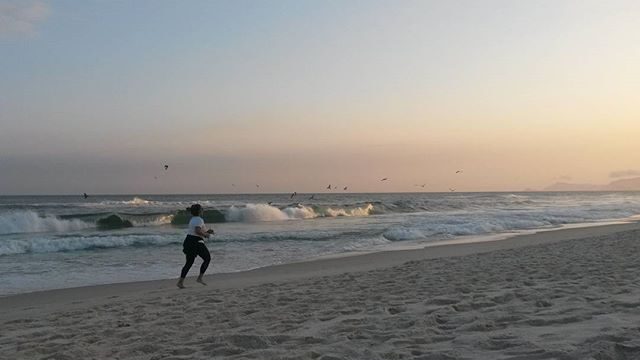 Mulher correndo na praia pela manhã. A foto mostra um hábito e faz referência a sua importância na construção de uma estratégia de Onboarding de cliente de sucesso.