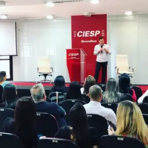 Em um palco, o autor fala aos associados do CIESP-Guarulhos. Foto de 2023.